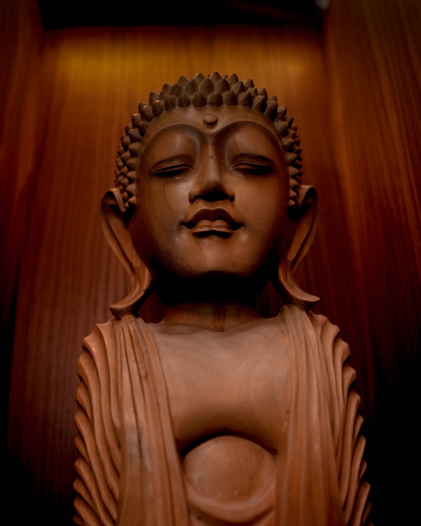 A carved wooden figure lit from above
